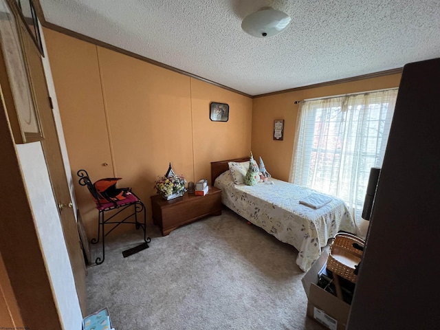 carpeted bedroom featuring ornamental molding, lofted ceiling, and a textured ceiling