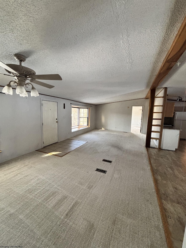 unfurnished living room with ceiling fan, a textured ceiling, and carpet