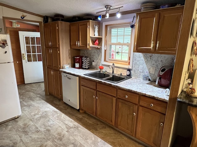 kitchen featuring sink, a textured ceiling, white appliances, and decorative backsplash