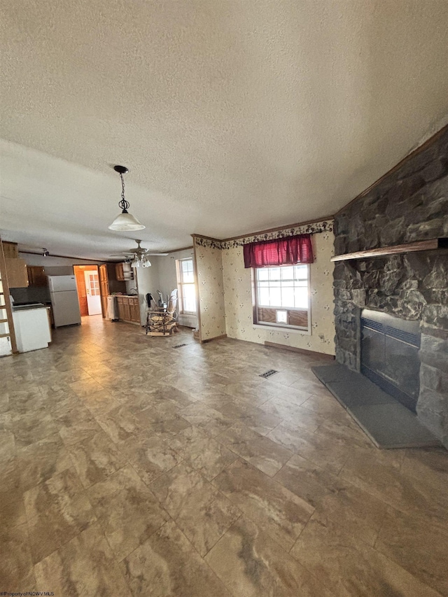 unfurnished living room with a fireplace and a textured ceiling