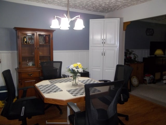 dining space featuring dark hardwood / wood-style flooring, a textured ceiling, and an inviting chandelier