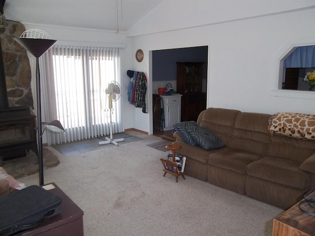 living room with lofted ceiling, a wood stove, and light colored carpet