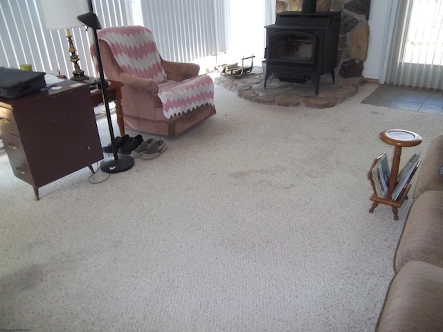 carpeted living room featuring a wood stove