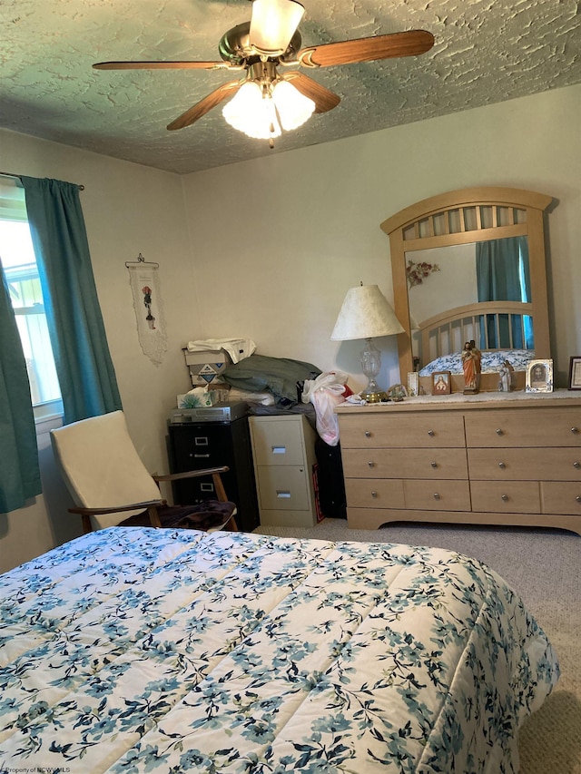 bedroom with ceiling fan, a textured ceiling, and carpet