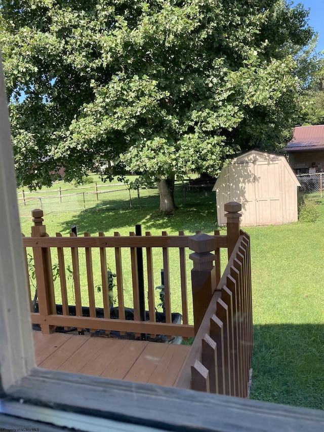 wooden deck with a storage shed and a yard