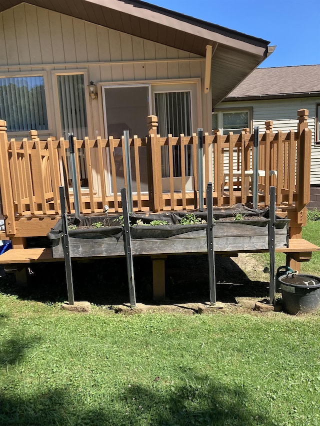 back of property with a wooden deck and a lawn