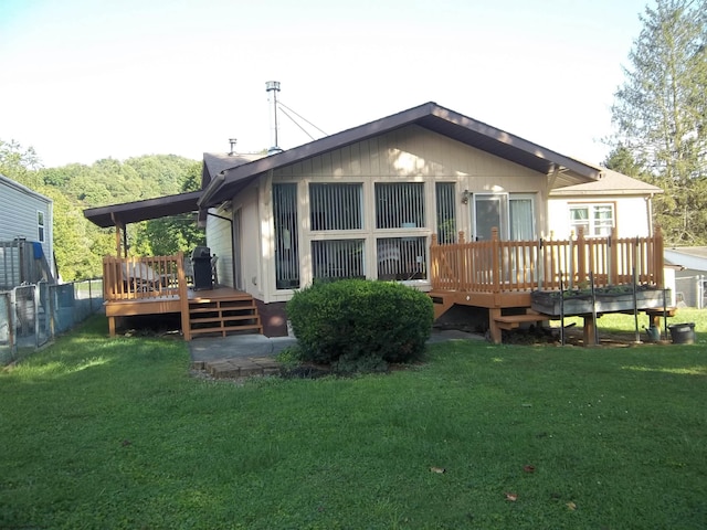 back of property with a wooden deck and a yard