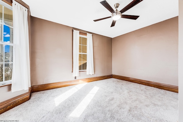 carpeted spare room featuring ceiling fan