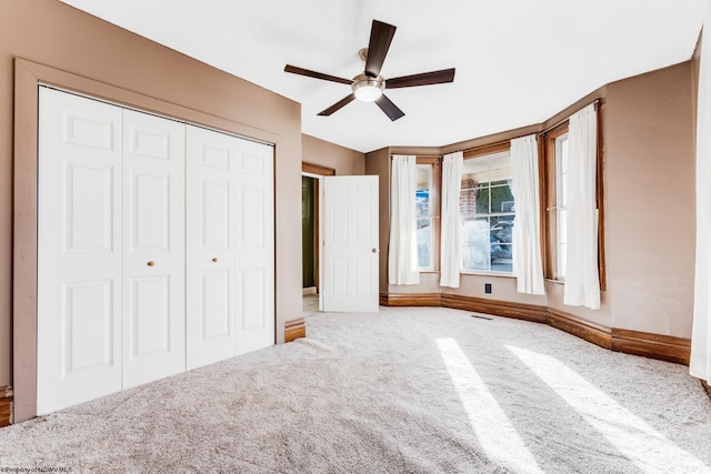 unfurnished bedroom featuring ceiling fan, carpet flooring, and a closet