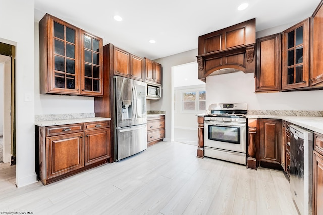 kitchen featuring light stone counters, appliances with stainless steel finishes, and light wood-type flooring