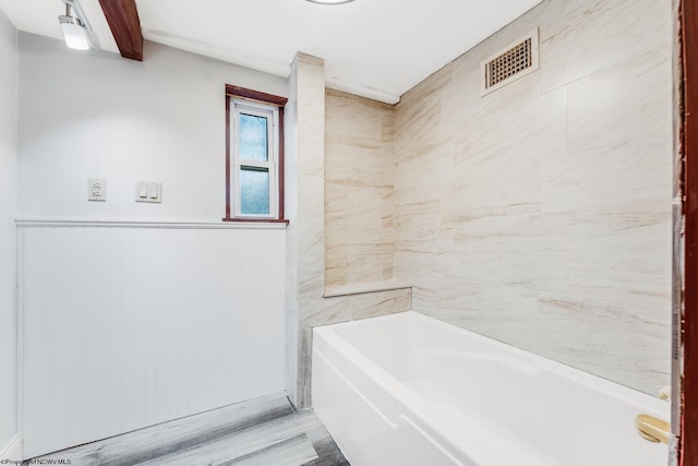 bathroom featuring a tub to relax in and wood-type flooring