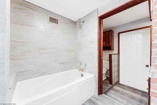 bathroom with hardwood / wood-style flooring and toilet