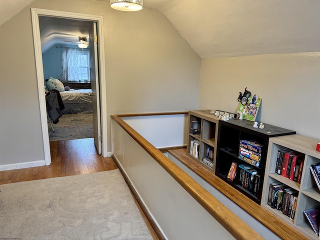 hall with hardwood / wood-style floors and vaulted ceiling