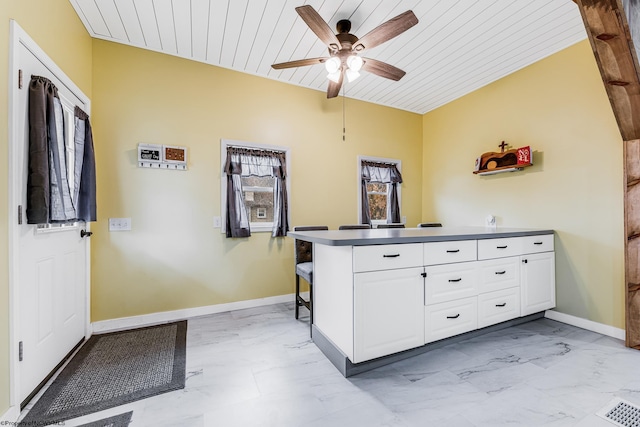 interior space with ceiling fan, white cabinets, wood ceiling, and kitchen peninsula