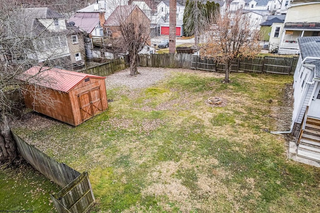 view of yard with a storage shed and an outdoor fire pit