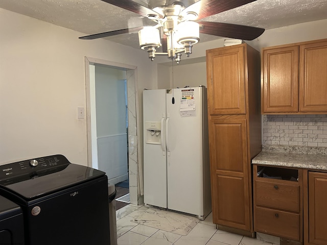 kitchen featuring washer / clothes dryer, decorative backsplash, white refrigerator with ice dispenser, ceiling fan, and a textured ceiling