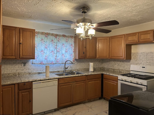 kitchen with sink, white appliances, ceiling fan, backsplash, and a textured ceiling