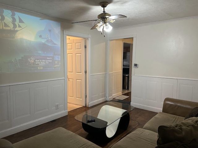 living room with dark hardwood / wood-style flooring, ceiling fan, crown molding, and a textured ceiling