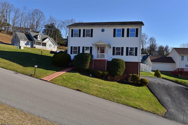 colonial-style house featuring a front yard