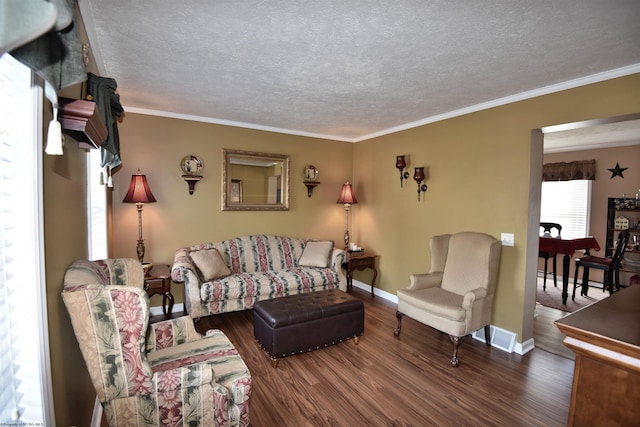 living room with dark hardwood / wood-style flooring, ornamental molding, and a textured ceiling