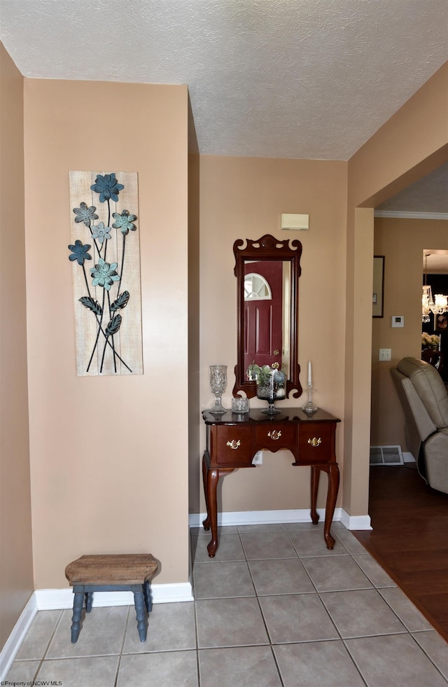 hall featuring tile patterned flooring and a textured ceiling