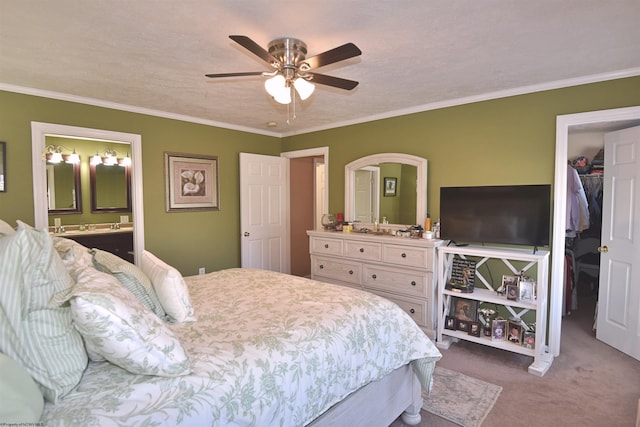 bedroom featuring crown molding, a spacious closet, and carpet floors