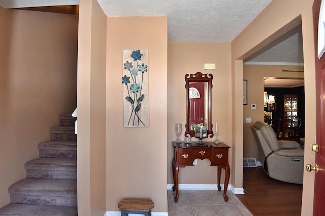 tiled entryway with a textured ceiling