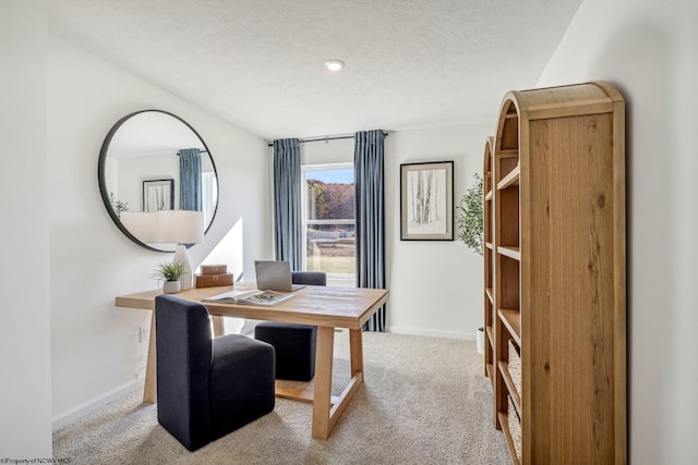 carpeted home office with a textured ceiling