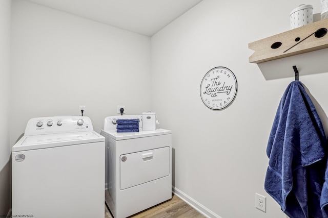 washroom with washing machine and dryer and light wood-type flooring