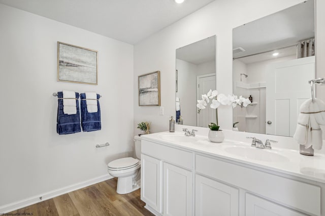 bathroom with vanity, wood-type flooring, toilet, and a shower