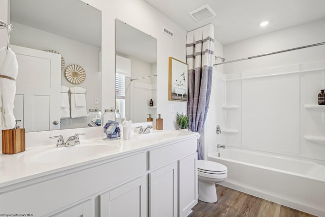 full bathroom featuring vanity, toilet, hardwood / wood-style floors, and shower / bath combo