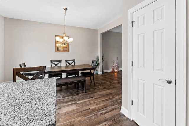 dining space with dark wood-type flooring and an inviting chandelier