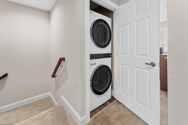 washroom with stacked washer / drying machine and carpet flooring