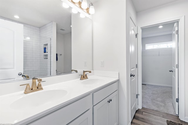 bathroom featuring vanity, wood-type flooring, and a tile shower