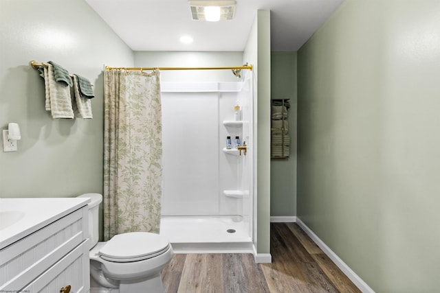 bathroom with vanity, hardwood / wood-style floors, walk in shower, and toilet