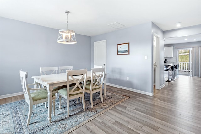 dining room featuring a notable chandelier and light wood-type flooring