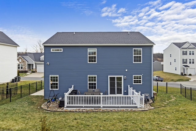 rear view of house featuring a wooden deck and a lawn