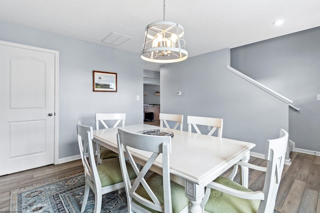 dining room with a notable chandelier and dark hardwood / wood-style flooring