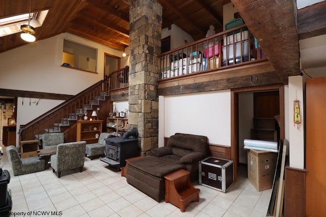 living area with tile patterned flooring, a wood stove, stairs, wood ceiling, and high vaulted ceiling