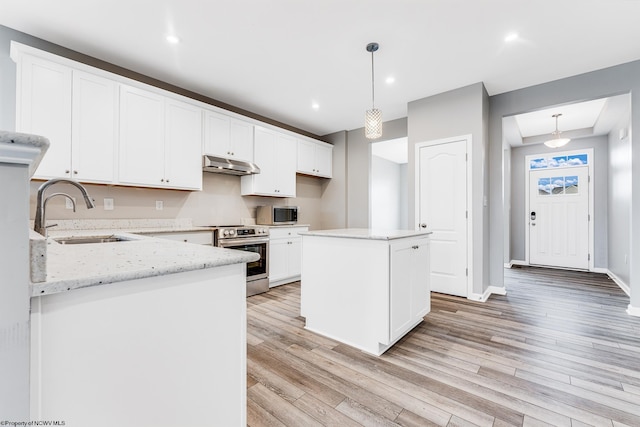 kitchen featuring sink, appliances with stainless steel finishes, white cabinetry, hanging light fixtures, and a center island