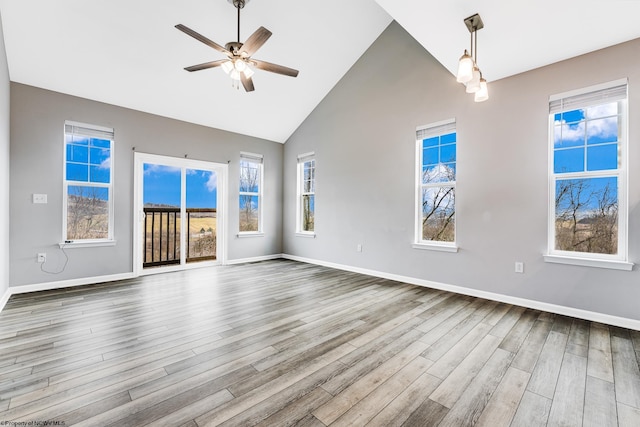 unfurnished living room featuring hardwood / wood-style flooring, ceiling fan, and high vaulted ceiling