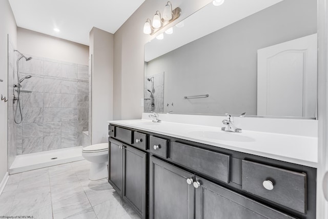 bathroom featuring vanity, toilet, and a tile shower