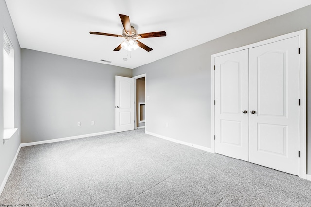 unfurnished bedroom featuring carpet, ceiling fan, and a closet