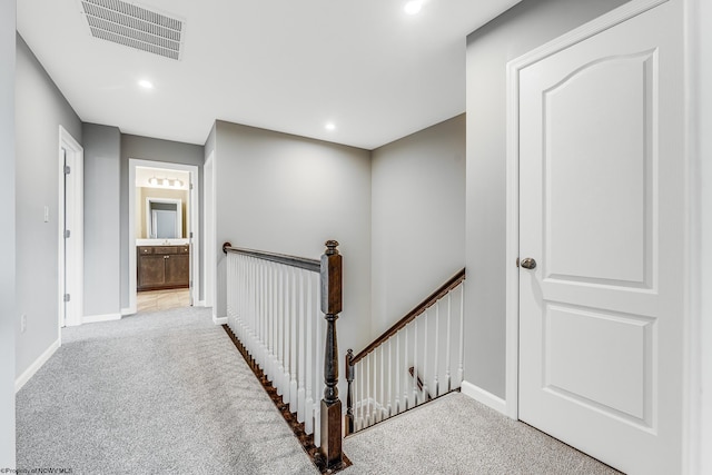 hallway with light colored carpet