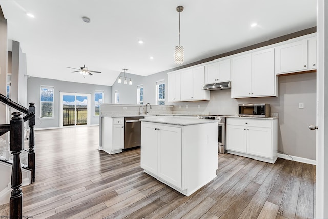 kitchen featuring white cabinetry, a center island, pendant lighting, ceiling fan, and stainless steel appliances