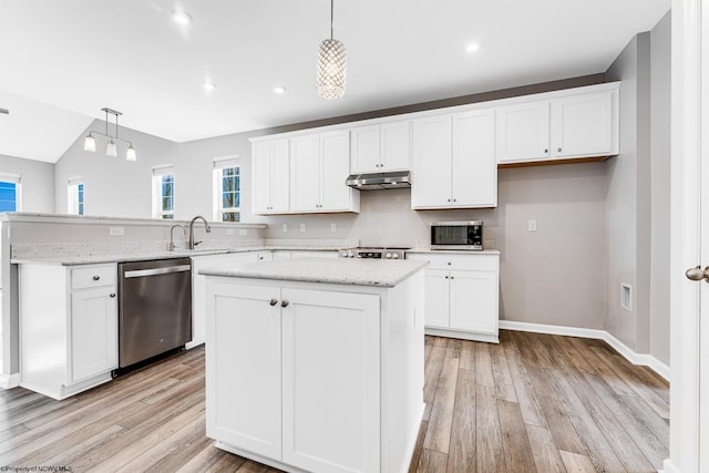 kitchen with appliances with stainless steel finishes, decorative light fixtures, a kitchen island, and white cabinets