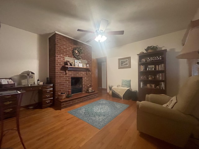 living room with ceiling fan, a fireplace, and wood-type flooring