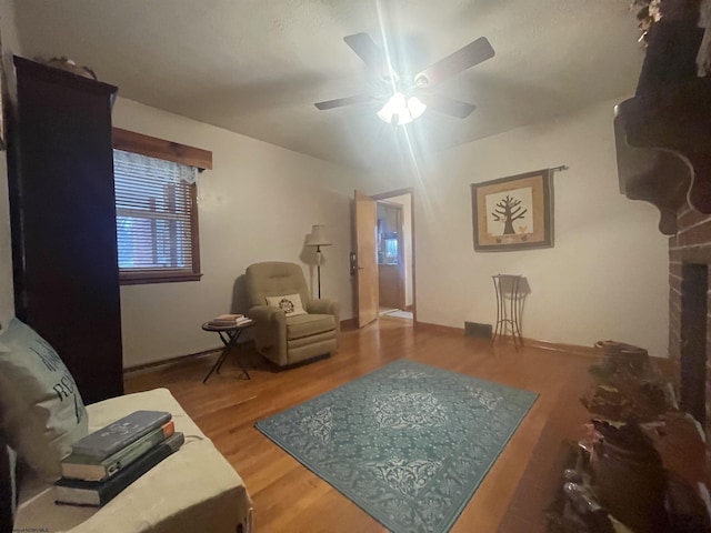 living room featuring hardwood / wood-style floors and ceiling fan