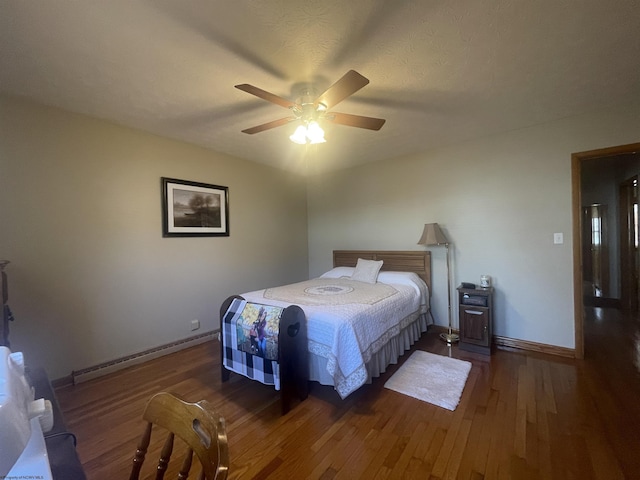 bedroom with baseboard heating, ceiling fan, and dark hardwood / wood-style flooring