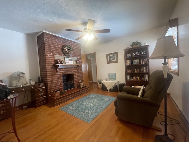 living room with a textured ceiling, a fireplace, and wood-type flooring